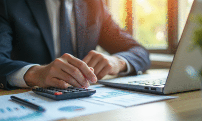 Jeune professionnel analysant documents financiers avec ordinateur